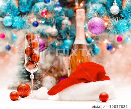 red glitter balls in a large wine glass against the background of a decorated blue Christmas 59837822