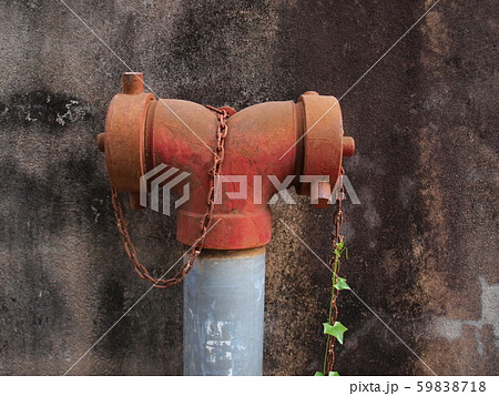 Closeup red fire hydrant, red fire extinguisher in front of the old wall On the background of the old cement wall 59838718