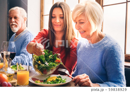 Family sitting at home, eating salad on dinner 59838929