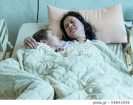 Chinese mother and daughter laying in hosital bed 59841956