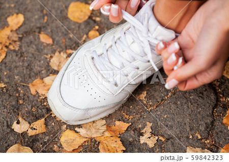 Woman Runner Tightening Shoe Lace. Runner Woman Feet Running On Road Closeup On Shoe Woman Runner Tightening Shoe Lace. Runner Woman Feet Running On Road Closeup On Shoe 59842323