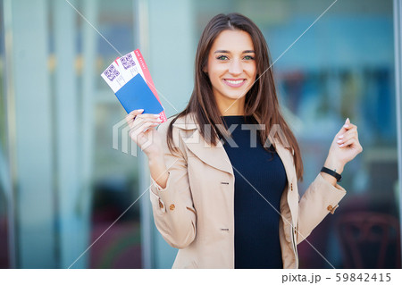 Travel. Woman holding two air ticket in abroad passport near airport Travel. Woman holding two air ticket in abroad passport near airport 59842415