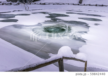 Fish pond with melting ice on water surface 59842440