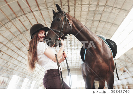 A happy girl communicates with her favorite horse. The girl loves animals andhorseback riding A happy girl communicates with her favorite horse. The girl loves animals andhorseback riding 59842746