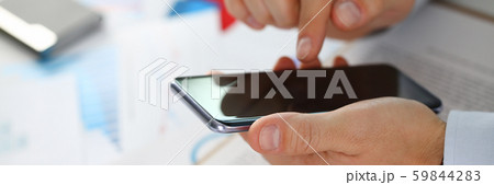 A businessman holds a new smartphone A businessman holds a new smartphone 59844283