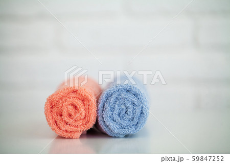 Colorful cotton towels in bathroom on white wooden table Colorful cotton towels in bathroom on white wooden table 59847252