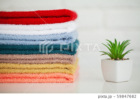 Fluffy bath towels on light wooden table with decor and white background Fluffy bath towels on light wooden table with decor and white background 59847682