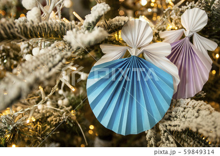 New Year handmade angel papercraft origami figures on christmas tree with holiday interior snow 59849314