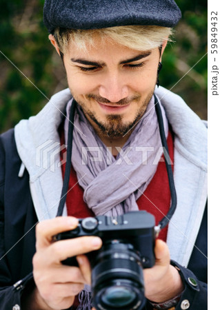 Hipster Street Photographer Reviewing Pictures On Mirrorless Camera Display 59849432
