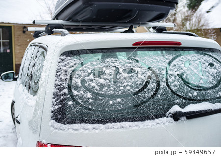 Children painted a smiling face on the snow-covered windows of the car. Family vacation during the Children painted a smiling face on the snow-covered windows of the car. Family vacation during the 59849657