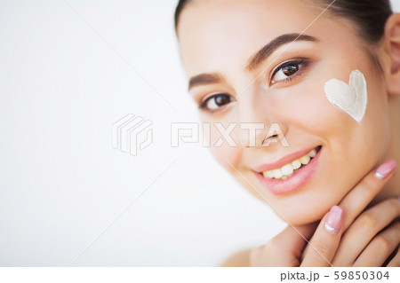 Skin Care. Beautiful model applying cosmetic cream treatment on her face 59850304