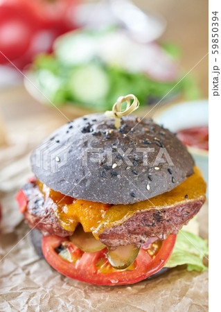 Cheeseburger with lettuce, tomato, fries, and melted cheese. The table in the restaurant. Unhealthy Cheeseburger with lettuce, tomato, fries, and melted cheese. The table in the restaurant. Unhealthy 59850394