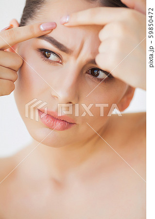 Skin Care. Young woman try to remove her pimple Skin Care. Young woman try to remove her pimple 59850472