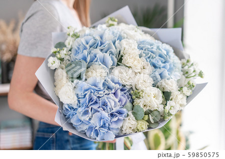 European floral shop. Beautiful bouquet of mixed flowers in womans hands. the work of the florist at 59850575