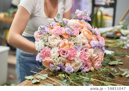European floral shop concept. Florist woman creates beautiful bouquet of mixed flowers. Handsome European floral shop concept. Florist woman creates beautiful bouquet of mixed flowers. Handsome 59851047