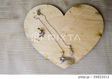 A wooden heart for Valentine's Day with silver earrings with diamonds, precious stones, rhinestones A wooden heart for Valentine's Day with silver earrings with diamonds, precious stones, rhinestones 59852013