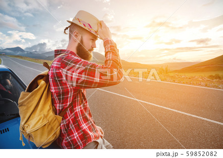 Portrait of a bearded happy serious traveler hipster with a backpack in a plaid shirt and a hat next 59852082