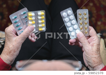 Closeup of a tablet on the hands of an old woman. The concept of choosing medication in old age Closeup of a tablet on the hands of an old woman. The concept of choosing medication in old age 59852370