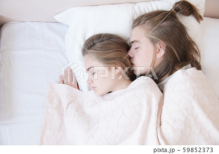 Close-up of a young couple in bed sleeping in an embrace, hiding behind a blanket. The concept of a 59852373