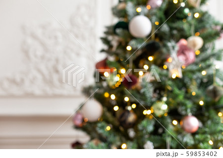 Blured photo of shiny toys and garland hanging on fir branches 59853402