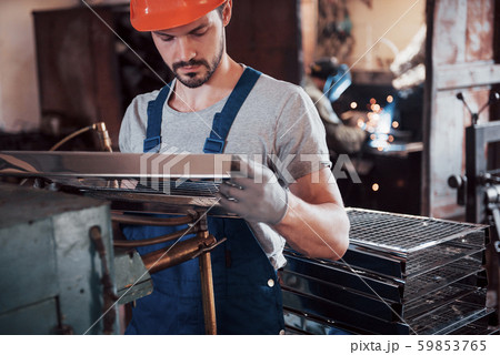 Portrait of a young worker in a hard hat at a large waste recycling factory. The engineer monitors Portrait of a young worker in a hard hat at a large waste recycling factory. The engineer monitors 59853765