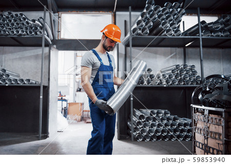 Portrait of a young worker in a hard hat at a large metalworking plant. Shiftman on the warehouse of Portrait of a young worker in a hard hat at a large metalworking plant. Shiftman on the warehouse of 59853940