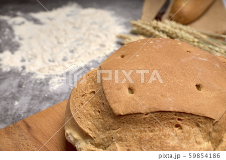 Rustic bread and wheat spikes on a grey background 59854186