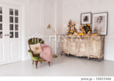Blurred photo of dresser with Christmas decorations standing on it stands next to chair 59855466