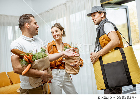 Courier delivering groceries for a couple home 59858347