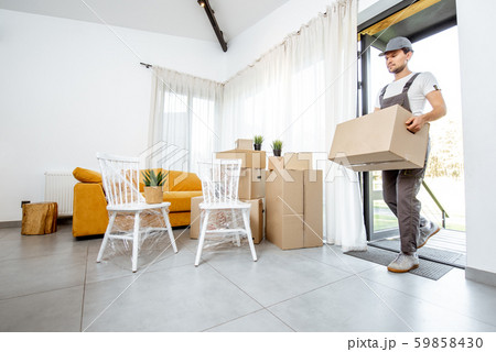 Professional mover delivering furniture to a new house 59858430