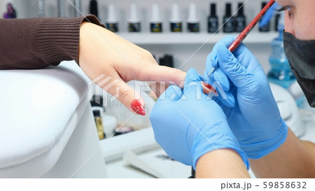 Master applies varnish drawing on nails gel in manicure salon 59858632