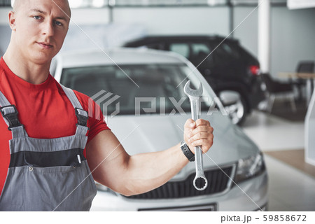 Hands of car mechanic with wrench in garage Hands of car mechanic with wrench in garage 59858672