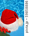 Santa Claus hat on a branch of spruce and toys. 59858886