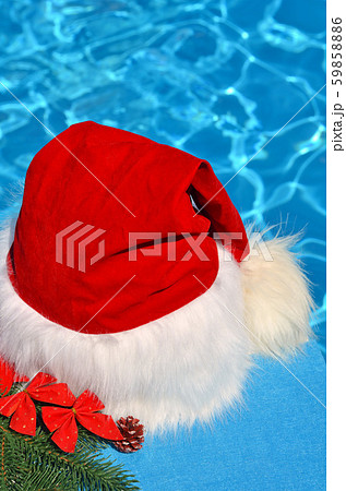 Santa Claus hat on a branch of spruce and toys. 59858886