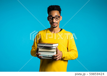 African student is dissatisfied with amount of homework,books. Man in glasses 59859424