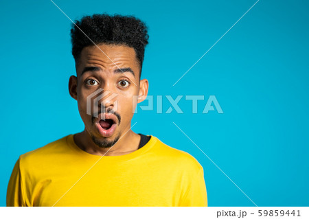 Amazed mixed race man shocked, saying WOW. African guy with afro hair surprised 59859441