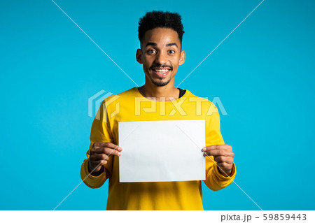 Portrait african man holding white empty paper blank on blue studio background 59859443