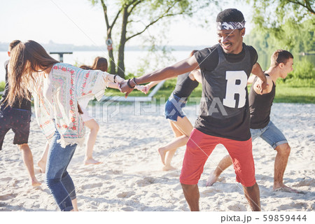 Happy friends have fun on the beach - Young people playing in open air water on summer holidays 59859444