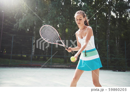 Woman in sportswear serves tennis ball. 59860203