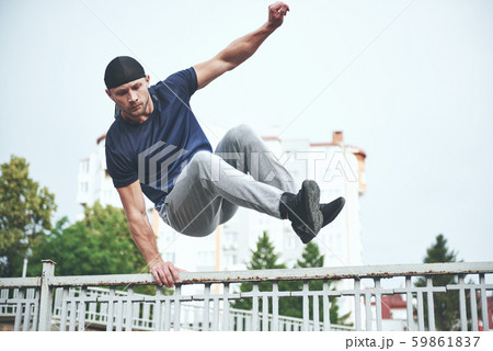 Young sports man doing parkour in the city. Young sports man doing parkour in the city. 59861837
