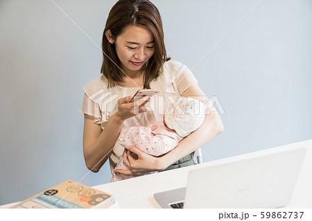 赤ちゃんの写真を撮る母親 59862737