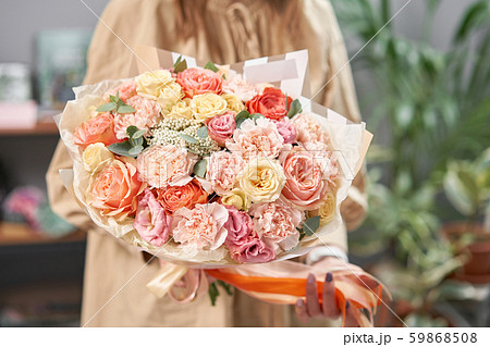 Modern floral shop. Finished work of the florist. Cute bouquet of mixed flowers in womans hands Modern floral shop. Finished work of the florist. Cute bouquet of mixed flowers in womans hands 59868508