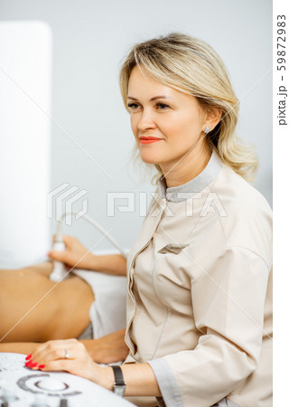 Doctor performs ultrasound examination of a woman 59872983
