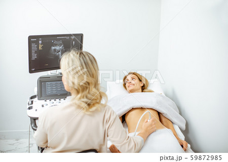 Doctor performs ultrasound examination of a woman 59872985