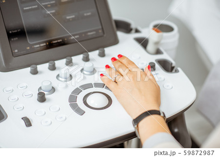 Doctor controling ultrasound machine 59872987