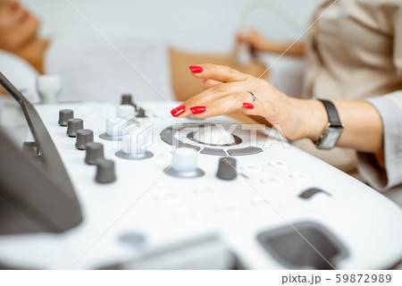 Doctor controling ultrasound machine 59872989
