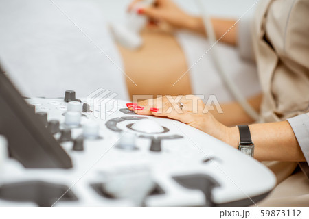 Doctor performs ultrasound examination of a woman 59873112
