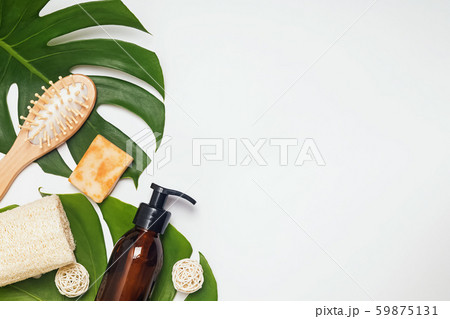 Natural hair and body care products lying on monstera leaves 59875131