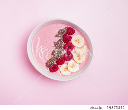 Delicious smoothie bowl with raspberries and chia seeds on pink background Delicious smoothie bowl with raspberries and chia seeds on pink background 59875832