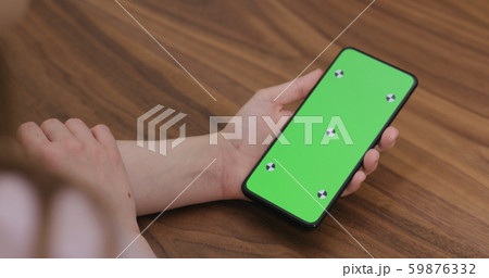 young woman holding smartphone over walnut table 59876332